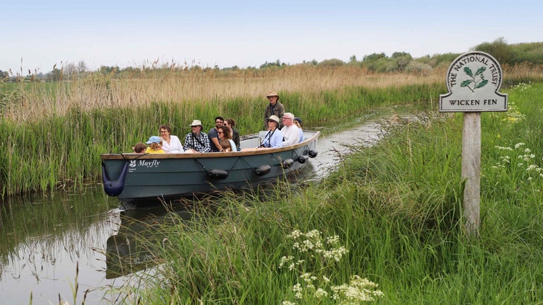 Visitors on a boat trip at Wicken Fen National Nature Reserve, Cambridgeshire